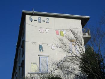 壁面に洗濯が干されている立体アート
