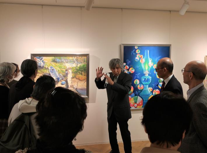 昨年度市展の合評会のようす。作品の前に審査員と受賞者などが集まっています。