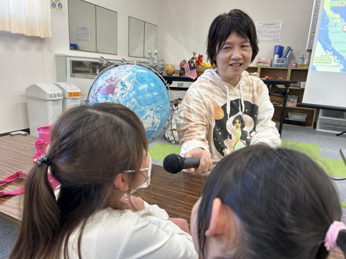 子どもにマイクを向ける女性
