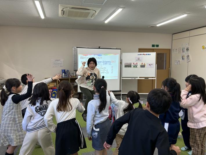 子どもたちとじゃんけんをする女性