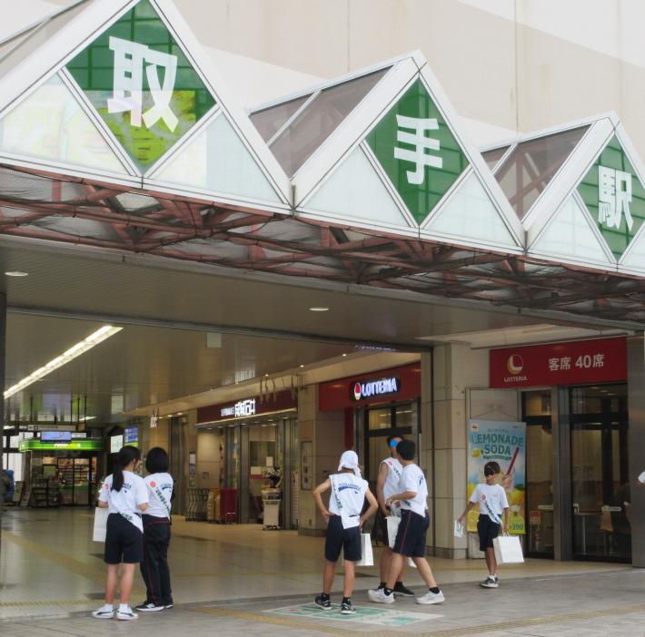 駅ビルの入り口付近に立つ中学生
