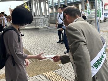 啓発グッズを配布する男性とそれを受け取る女性