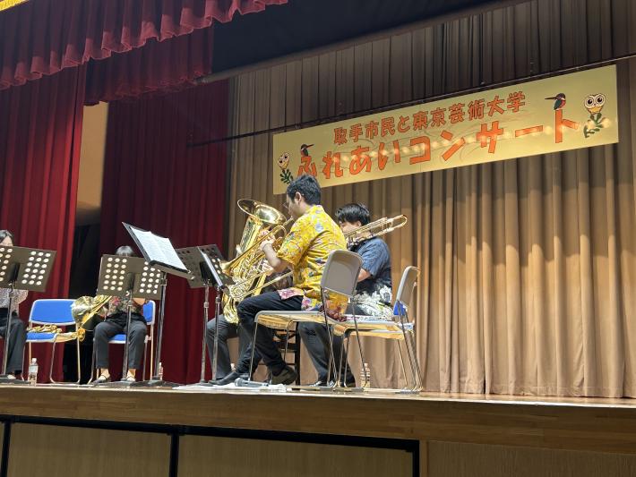 金管楽器を壇上で演奏する大学生たち