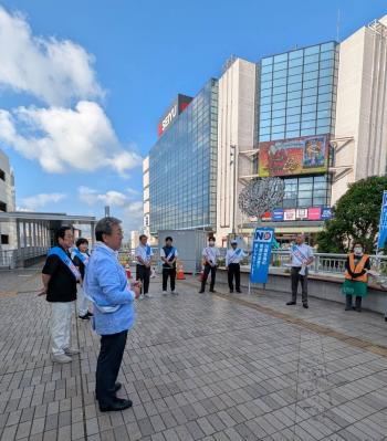 駅ビルの前であいさつをする男性