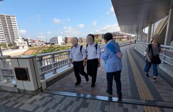 啓発グッズを駅の通行者に配布する男性