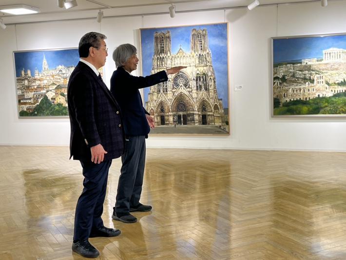 壁にかかった絵画を鑑賞する男性2名