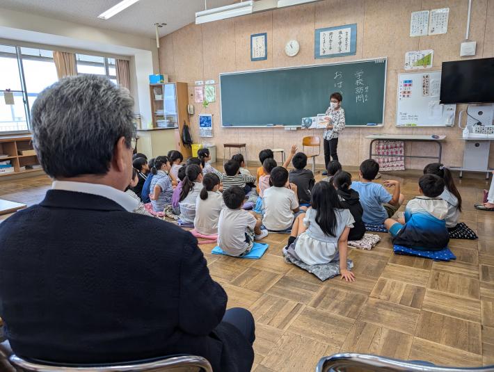 床に座って絵本の読み聞かせを聞く子どもたち