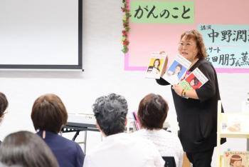女性が冊子を3冊持って話している
