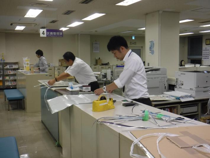 段ボールに張り付ける職員