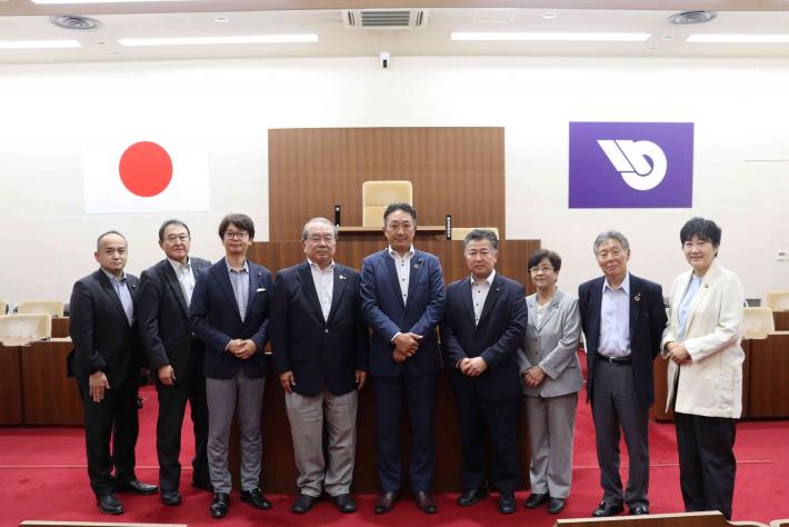 秋田県大仙市議会の議員らが横一列に並んで記念撮影をしている様子