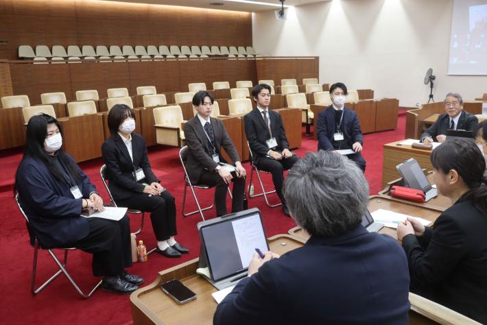 総務文教常任委員会の委員を中心とした議員らと所管課の新規採用職員らが取手市議会議場で意見交換をしている様子