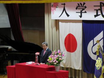 入学式と書かれた看板の下で挨拶をする市長