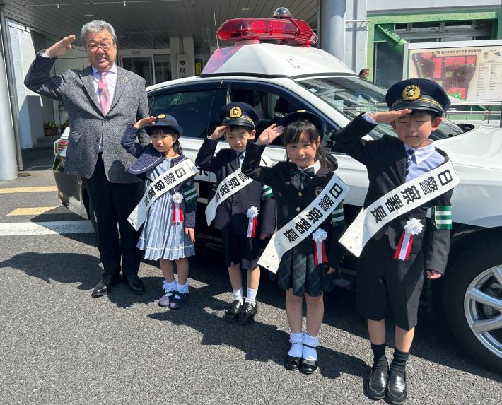 敬礼をする4名の一日警察署長と市長
