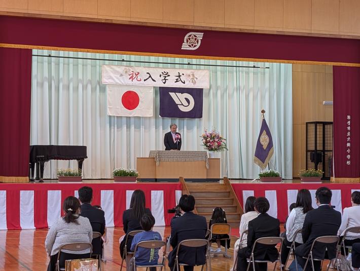 小学校の入学式にて壇上で挨拶をする市長