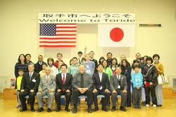 来市時にユーバ市民のみなさんと出迎えたホストファミリーが多目的ホールで記念撮影を行っている様子。