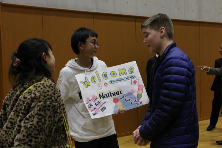 歓迎のプラカードをもつ取手市の学生とユーバ市民