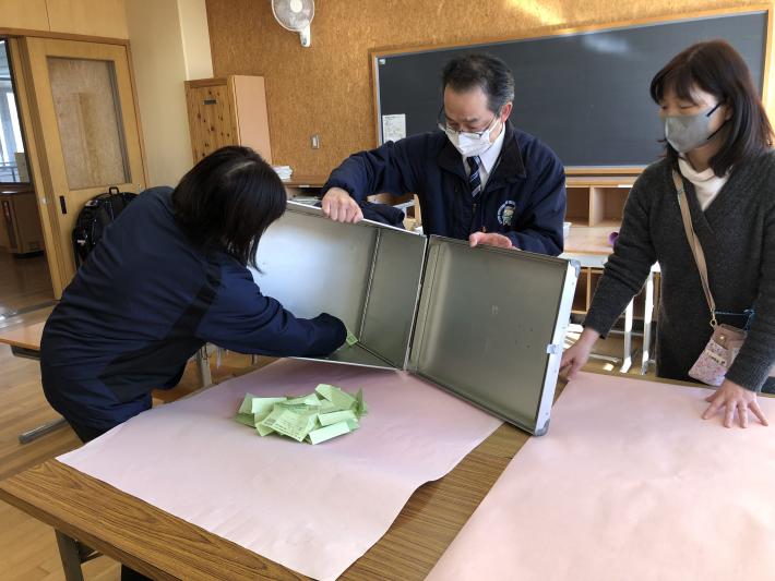 投票用紙が投票箱から取り出されている