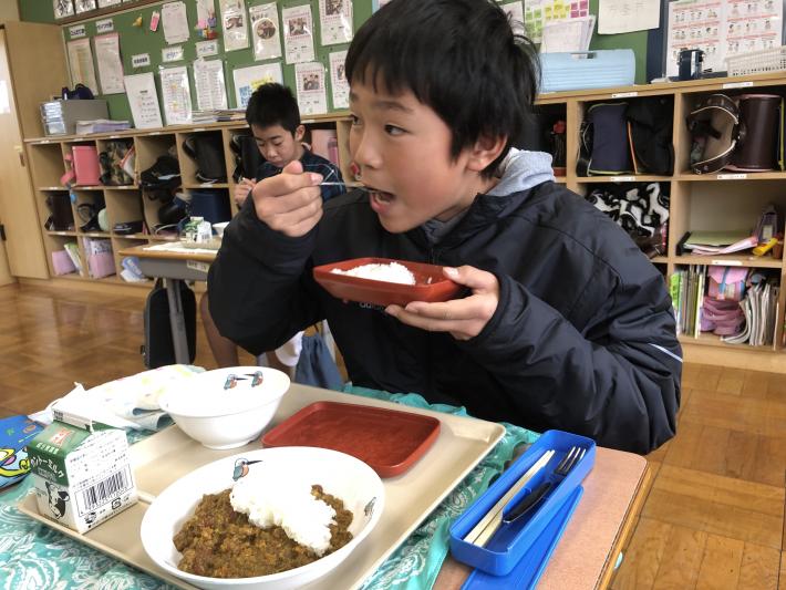 大口を開けてご飯を食べる男の子