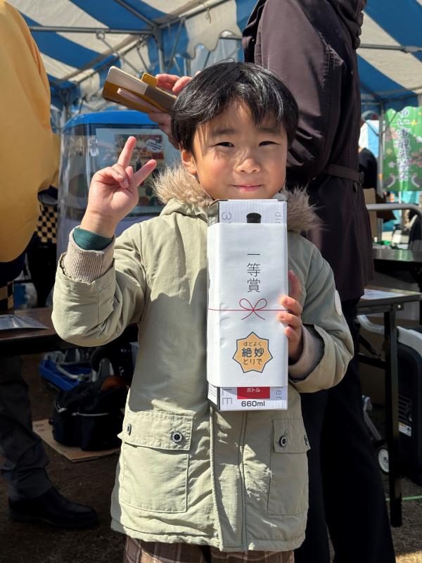一等賞と書かれた四角い箱を持った男の子がピースしている