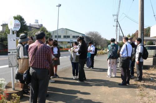 バス停のそばに集まっている人々の写真