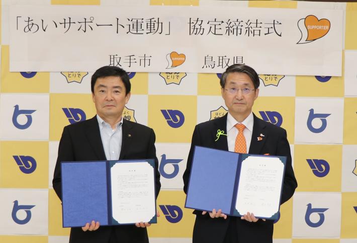 藤井元市長と平井鳥取県知事が協定書を持ち並んで立っている写真