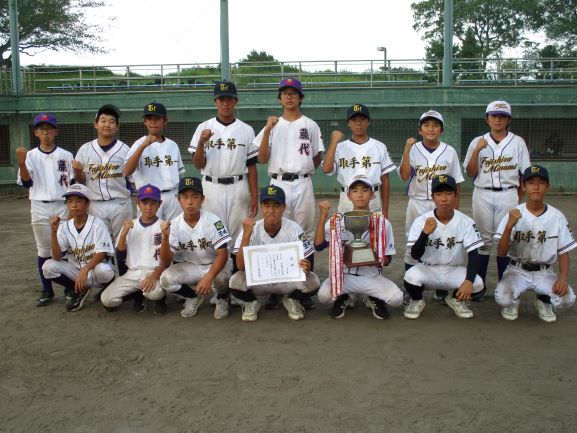 野球新人戦優勝カップと賞状をもって全体写真を撮っている様子の先生と生徒。